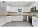 Beautiful modern kitchen with white cabinets, stainless steel appliances, wooden countertop and updated flooring at 915 E Holly St, Rocky Mount, NC 27801