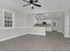 Bright living room featuring gray floors, white walls, a ceiling fan, and an open kitchen view at 915 E Holly St, Rocky Mount, NC 27801