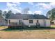 View of the backyard and home with a spacious lawn area and wooden deck with outdoor seating at 1001 Strobus Ct, Wendell, NC 27591