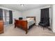 Comfortable bedroom with a classic wooden bed frame, dark curtains, and a serene, relaxing atmosphere at 1001 Strobus Ct, Wendell, NC 27591