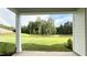 Scenic back yard with a rainbow, lush green grass, and mature trees, viewed from the covered patio at 1013 Greatland Road, Durham, NC 27703
