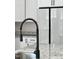 Close-up of a kitchen faucet and sink area with granite countertops and white cabinets at 1013 Greatland Road, Durham, NC 27703
