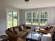 Cozy living room with large windows, a sliding glass door, hardwood floors, and comfortable, vintage furniture at 1013 Greatland Road, Durham, NC 27703