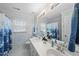 Well-lit bathroom features double sinks, a large mirror, and decorative shower curtain at 107 White Sands Dr, Cary, NC 27513