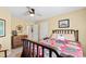 Bedroom featuring wooden furniture, ceiling fan, cozy atmosphere, and view of stairway at 10700 Chesson Dr, Raleigh, NC 27614