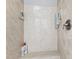 Shower stall with neutral stone-look walls, built-in bench, and chrome fixtures at 10700 Chesson Dr, Raleigh, NC 27614