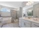 Modern bathroom featuring double sinks, bathtub, tiled shower, and white cabinets at 1100 Topaz Cave Cir, Raleigh, NC 27610