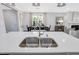 The kitchen features a large island with a stainless steel sink, white cabinets, and pendant lighting at 1100 Topaz Cave Cir, Raleigh, NC 27610