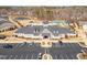 Aerial view of community clubhouse with pool, tennis courts, pond, parking, and manicured landscaping at 130 Ivory Ln, Raleigh, NC 27610