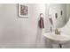 Powder room featuring a pedestal sink, round mirror, and modern decor for guests at 130 Ivory Ln, Raleigh, NC 27610