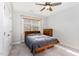 Cozy bedroom with a ceiling fan, window, and a wooden dresser, complemented by neutral walls and carpet at 130 Ivory Ln, Raleigh, NC 27610