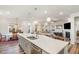 Open concept kitchen with island, stainless steel sink, shaker cabinets, and hardwood floors at 130 Ivory Ln, Raleigh, NC 27610