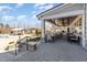 View of the covered patio with stone pillars, ceiling fans, multiple tables and chairs, and view of the pool at 130 Ivory Ln, Raleigh, NC 27610