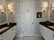 Bathroom boasts a patterned tile floor, black countertops, and dual sinks with mirrors and sconces at 1317 Pecora Ln, Raleigh, NC 27607