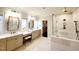 Bathroom featuring double vanity sinks, large mirrors, and a glass walk-in shower with bronze fixtures at 1317 Pecora Ln, Raleigh, NC 27607
