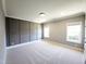 Bedroom showcasing neutral carpeting, a gray accent wall with wainscoting, and natural light from two windows at 1317 Pecora Ln, Raleigh, NC 27607