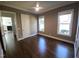 Bedroom features dark hardwood floors, two large windows, and an open doorway to another room at 1317 Pecora Ln, Raleigh, NC 27607