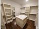 Walk-in closet featuring an island, hardwood floors, shelving and hanging storage at 1317 Pecora Ln, Raleigh, NC 27607