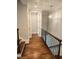 Hallway with wood floors, metal railing and stairs leading to another level of the home at 1317 Pecora Ln, Raleigh, NC 27607