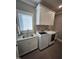 Well-equipped laundry room features modern washer and dryer, granite countertop, and ample cabinet space at 1317 Pecora Ln, Raleigh, NC 27607