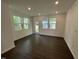 Bright and airy living room with hardwood floors and large windows with backyard view at 1551 Crescent Townes Way, Raleigh, NC 27604