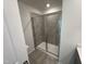 Modern bathroom shower featuring gray tile surround and a clear glass door at 1551 Crescent Townes Way, Raleigh, NC 27604