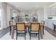 Bright dining area boasts a large table with seating, with a view of the modern kitchen at 1752 Post Oak Dr, Haw River, NC 27258