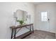 A bright entryway featuring a decorative front door, stylish console table, mirror, lamps, rug and wood flooring at 1752 Post Oak Dr, Haw River, NC 27258
