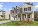 Charming two-story home featuring brick accents, gray shutters, a two-car garage and a well-manicured front lawn at 1752 Post Oak Dr, Haw River, NC 27258