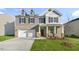 Charming two-story home featuring brick accents, red shutters, a two-car garage and a well-manicured front lawn at 1752 Post Oak Dr, Haw River, NC 27258