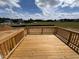 View of wooden back deck with railing overlooking the expansive back yard at 190 Sage Ln # 015, Four Oaks, NC 27524