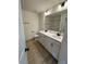 Bathroom with double sinks, white cabinets, and a large mirror at 190 Sage Ln # 015, Four Oaks, NC 27524