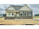 New home construction with stone and siding exterior and an 'Available' sign in the front yard at 190 Sage Ln # 015, Four Oaks, NC 27524