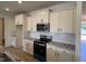 Modern kitchen with white cabinets, granite countertops, stainless steel appliances, and tile backsplash at 190 Sage Ln # 015, Four Oaks, NC 27524