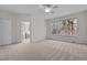 Spacious primary bedroom features large windows, ceiling fan and carpeted floor at 200 Indian Elm Ln, Cary, NC 27519