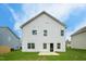 Exterior shot of a home's backyard with green lawn, a small patio and white siding at 209 Deodora Ln, Cameron, NC 28326