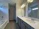 Modern bathroom featuring double vanity, quartz countertops, stylish fixtures, and tiled shower-tub combination at 209 Deodora Ln, Cameron, NC 28326