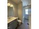 Full bathroom with tiled floor, gray vanity, white countertop, toilet, window, and shower-tub combination at 209 Deodora Ln, Cameron, NC 28326