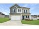 Two-story home with a two car garage, stone accents and a manicured lawn at 209 Deodora Ln, Cameron, NC 28326