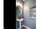 Half-bath with a pedestal sink, black faucet, wood look floors and decorative mirror at 209 Deodora Ln, Cameron, NC 28326