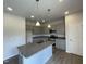 Modern kitchen boasting gray cabinets, granite countertops, a stainless steel microwave, and an island with a sink at 209 Deodora Ln, Cameron, NC 28326