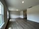 Open-concept living room featuring hardwood floors, neutral paint, and bright, sunlit windows at 209 Deodora Ln, Cameron, NC 28326