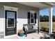 Covered front porch featuring a bench, pillows, potted plant, and black door with sidelight at 209 Deodora Ln, Cameron, NC 28326