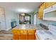 Open kitchen with a view into the dining area, featuring wooden cabinets and light countertops at 2105 Antioch Church Rd, Timberlake, NC 27583