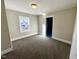 This bedroom features neutral colored walls, plush carpeting, and an open closet at 212 Craig Ave, Henderson, NC 27537