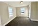 Cozy bedroom features neutral walls, plush carpeting, and bright natural light from two windows at 212 Craig Ave, Henderson, NC 27537