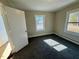 Bright bedroom filled with sunlight featuring a gray carpet and view of the yard through the windows at 212 Craig Ave, Henderson, NC 27537