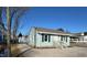 Quaint one-story home showcasing light blue siding, dark shutters, and a gravel driveway at 212 Craig Ave, Henderson, NC 27537