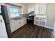 Bright kitchen with white cabinets, stainless steel appliances, and modern flooring at 212 Craig Ave, Henderson, NC 27537