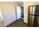 Open kitchen features white cabinets, stainless steel fridge, and hardwood style floors at 212 Craig Ave, Henderson, NC 27537
